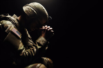 Soldier pray on black background - obrazy, fototapety, plakaty