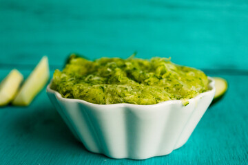 Grated zucchini mix in a white bowl, teal background!