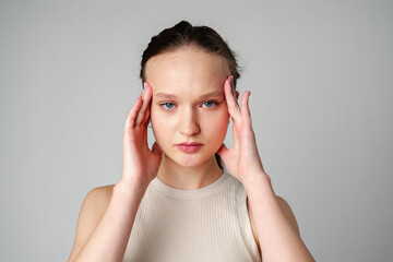 Young Woman Grimacing in Displeasure Against a Neutral Background