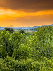 Landscapes of Transylvania. Vertical photo with an amazing sunset over the hills and villages of Transylvania in Harghita county. Travel to Romania country side.