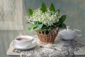 Still life with bouquet  lily of the valley on a tea table