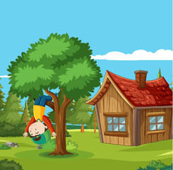 Happy boy hanging upside down from tree branch