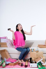 Tent to take young woman sitting on the sofa to use notebook computer Internet shopping