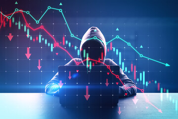 Hacker in hoodie sitting at desk and using laptop with falling red forex chart and map on dark...