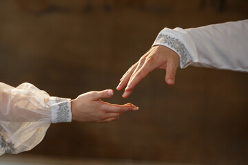 The hands of the bride and groom reach out to each other