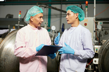 male workers meeting and talking about work or project in the beverage factory