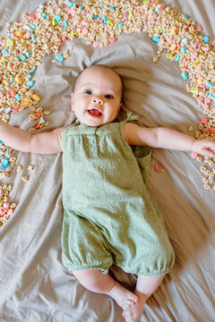 Smiling baby with cereal rainbow, celebrating St. Patrick's