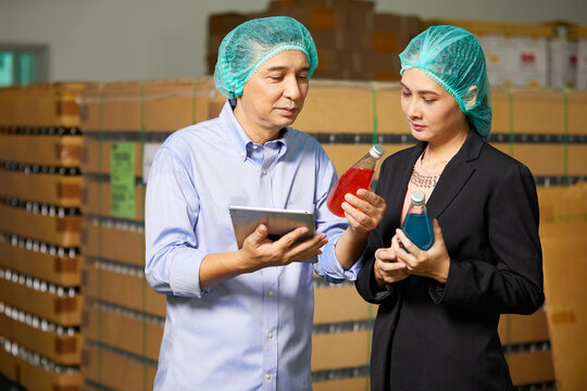 businessman and businesswoman checking basil seed drink or product in the beverage factory