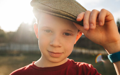 handsome boy wearing a flat cap at sunset