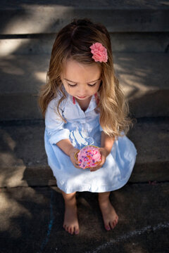 Beautiful little girl eating pink cupcake