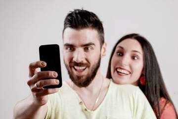 Couple laughs joyously, capturing selfie together
