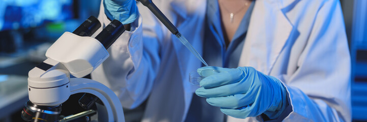 Scientist Working in the laboratory using a Micro Pipette. Mixing liquid chemicals with genetically...