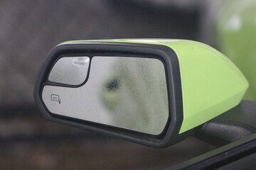 Selective focus on a green car's side mirror