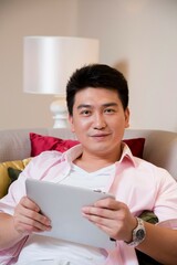 Middle-aged man reading a book in the living room