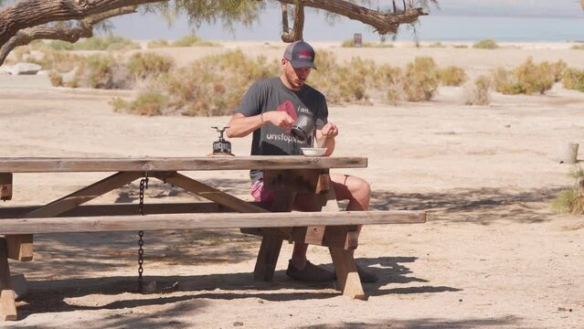 Male in his Thirties Prepare Breakfast  in the Morning At Salton Sea Campground - Static