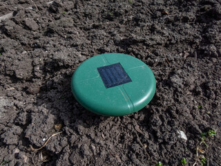 Close-up of the ultrasonic, solar-powered mole repellent or repeller device in the soil in a vegetable bed in the garden