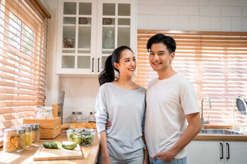 Portrait of Asian young couple spend time together in kitchen at home. 