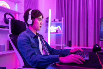 Asian young esport male gamer playing online video game on computer. 