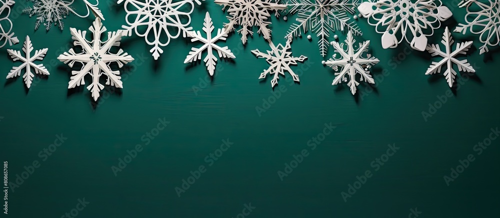 Poster a wintry decoration featuring white wooden snowflakes set against a green backdrop and ample copy sp