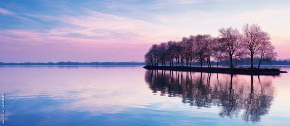 Poster in the morning the sunlight and trees cast their reflections on the water creating a picturesque sce