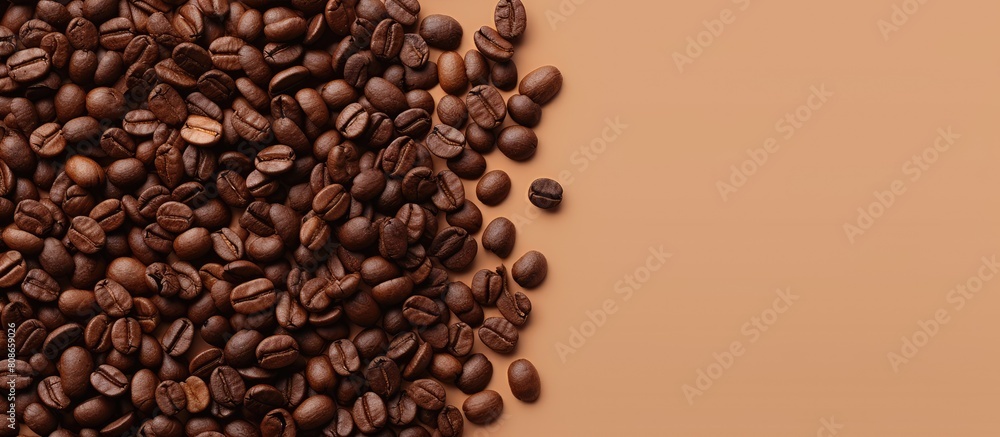 Aufkleber top view of roasted coffee beans scattered on a beige background creating a copy space image