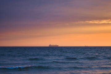 Schiff, Sonnenaufgang an der Ostsee, Strand mit Wellen auf der Insel Rügen, Ostseebad Binz, Mecklenburg Vorpommern, Deutschland	