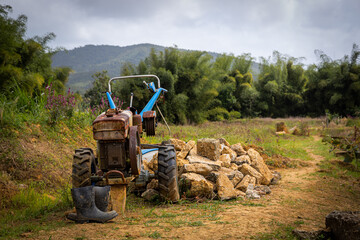 a tractor with buckets on the front is in front of a rock wall