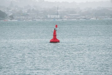 A red buoy floats in the harbor © Louis