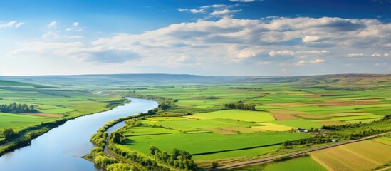 The copy space image shows a river meandering through beautiful fields and vibrant farms where the springtime farm work has yet to begin