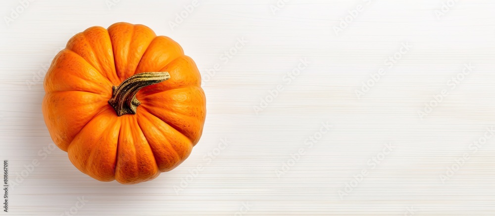 Poster top view of a pumpkin on a white table creating an autumn background with ample copy space for addit