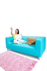 Shed young woman sitting on a couch surfing the Internet shopping