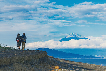 海辺から富士山を望むカップル