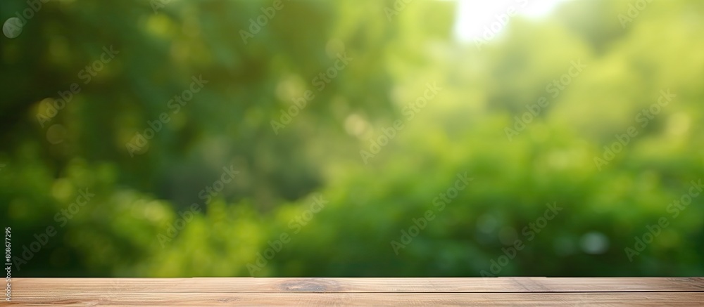 Poster a wooden table with no items on it set against a blurred green background providing ample space for 