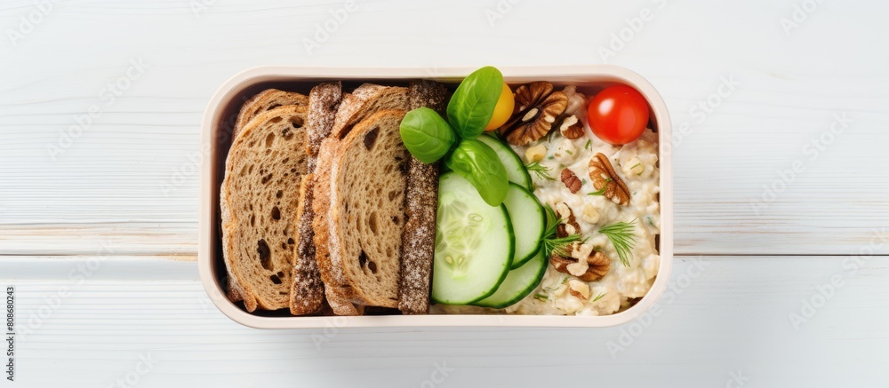 Poster top down view of a lunch box dinner filled with a nutritious assortment of oatmeal cucumber salad nu