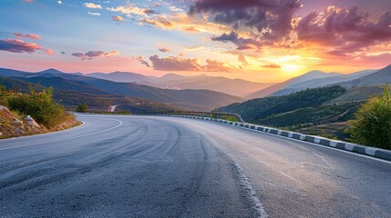 Fototapeta premium A sunrise view of a mountainous landscape and a paved road.
