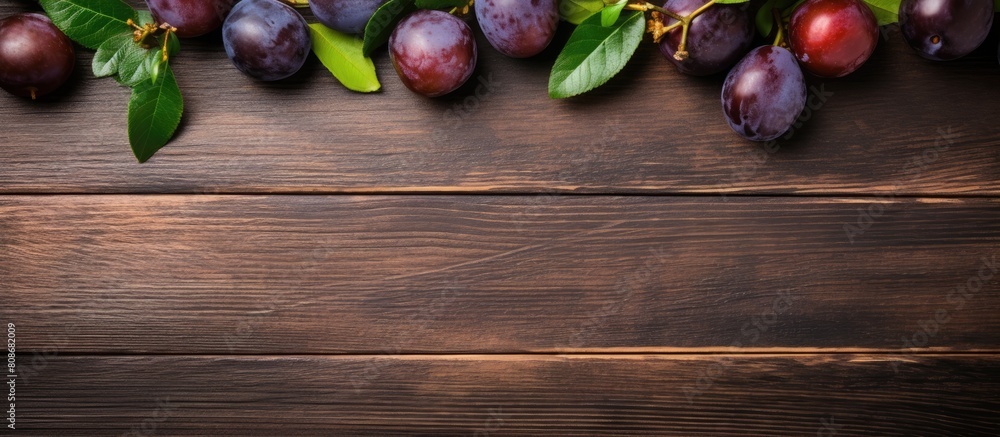 Poster from above a wooden table there is a view of plums and figs with ample copy space for writing or des