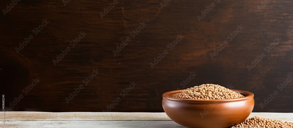 Sticker Wooden table with a bowl of uncooked buckwheat providing copy space for text