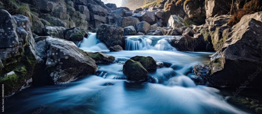 Poster a small river forms a white waterfall as it cascades over rocks creating a mesmerizing copy space im