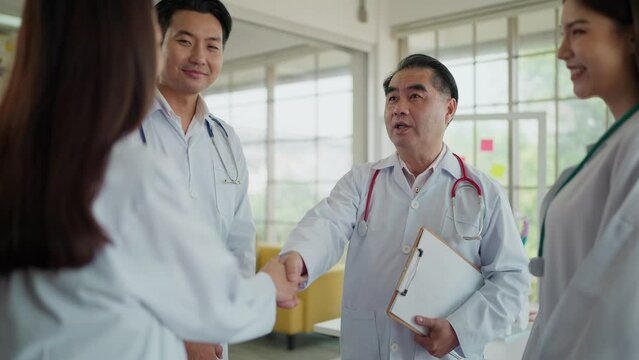 Team of asian doctors in white lab coat with stethoscope, shaking hands together, Joining the team, Congratulations or proud healthcare worker with handshake for medical collaboration