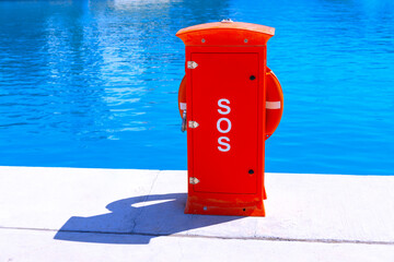 Red lifebuoy on the water edge with text SOS - Powered by Adobe