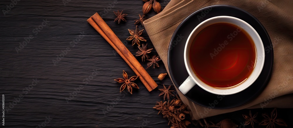 Poster an overhead view of black tea with cinnamon sticks and star anise creating a captivating copy space 