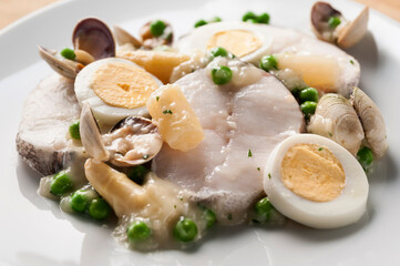 hake cooked with clams, asparagus, peas and hard-boiled egg