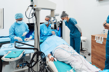 Skilled surgeon and his medical team performs precise eye surgery on an elderly patient, restoring...