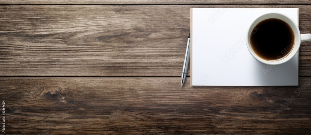 Aufkleber on a wooden table there is a pen paper and a coffee mug creating a visually appealing copy space ima