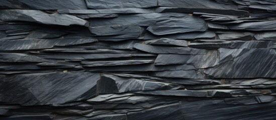 A top down view of a black slate stone texture creates a surface background with ample copy space for images