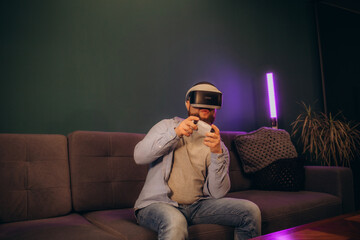 VR Headset. Asian man playing game on mobile phone with 3D simulation VR headset. Colorful neon...