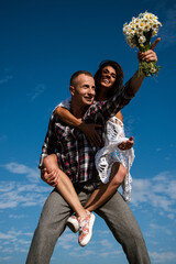 Crazy couple having fun outdoor. Young fun excited couple piggyback ride in summer day. Happy young...