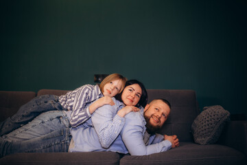 Dad, mom and daughter relaxing on the couch at home