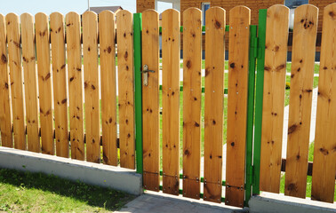 House wooden fence with doorway. Cozy wooden fencing.