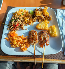 A plate full of thai and international cuisine.